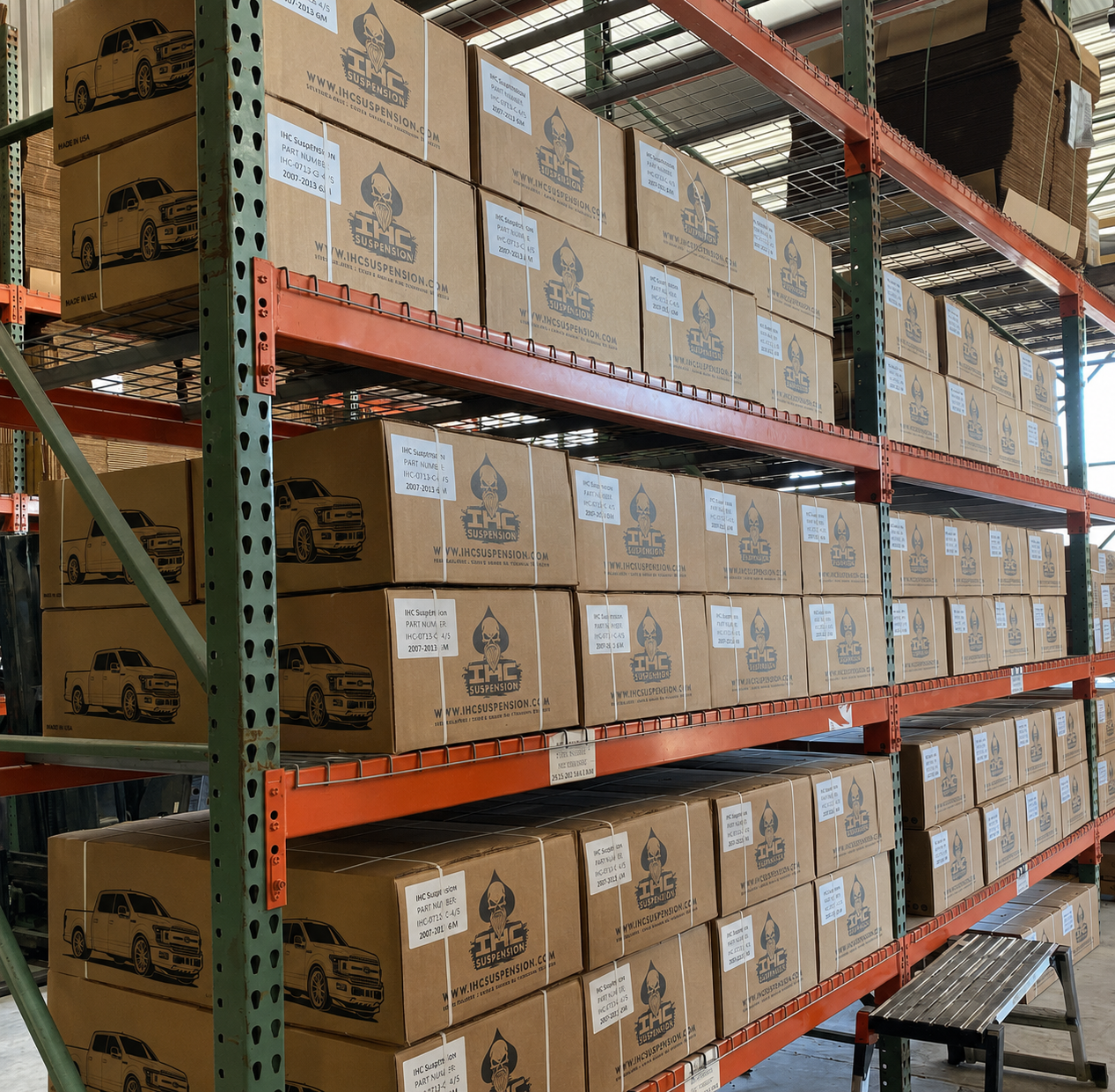 Printed IHC Suspension boxes stacked on warehouse racking, each carrying a truck illustration